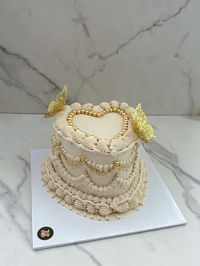 Elegant nude and gold vintage heart cake with gold butterflies and gold pearls