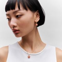 This b blossom necklace features a pendant crafted from a rounded and polished cornelian. Strung from a an 18-karat yellow-gold chain, the red-hued gemstone is inlaid with a monogram flower composed of four diamonds, a tribute to the motif designed by georges-louis vuitton in 1896. Delicate yet bold, this jewel can be worn alone or layered for a modern attitude.