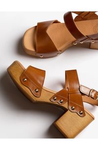 Gleaming midsole studs and a rich leather upper distinguish a retro-inspired sandal lifted by a woodgrain platform and block heel. 3" heel Leather upper and lining/synthetic sole Made in Spain