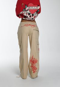 Ignite your style with the Women's Drag-Flame Cargo Trouser from our A/W Collection. These trousers, adorned with vintage-inspired tonal embroidery, celebrate Ed Hardy's iconic designs. Crafted for both comfort and bold fashion, wear yours as the canvas for your expression.- Regular Fit, Cargo Trouser- Sand 98% Cotton, 2% Spandex Blend- Monotone Graphic Embroidery- Adjustable Tie Fastening