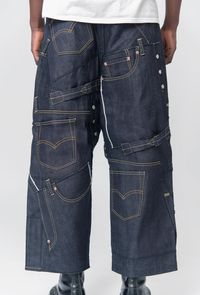 Cropped Junya Watanabe denim pants in Indigo Zip fly with button closure Multiple patch pockets and belt loops throughout Contrast stitching Stitched Levy's tab at front Cropped cuffs Wide, boxy fit Made in Japan 100% cotton Model is 6'1, 165lbs wearing size Medium.