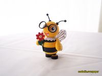 Quilled 3D bee with spectacles, round chubby body with a spiky sting tail and big white wings.