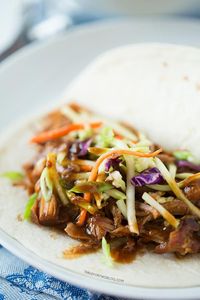 Slow cooker Korean tacos via tablefortwoblog.com. The tender & flavorful pork is wrapped inside a warm tortilla and topped with a tangy slaw...