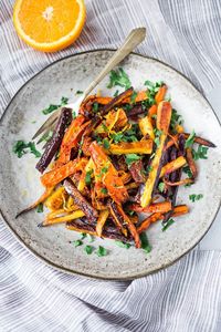 Sweet and Spicy Roasted Moroccan Carrots- with cumin, cinnamon and orange. A Delicious vegan side dish or serve over seasoned lentils for a hearty vegetarian meal. | www.feastingathome.com #carrots #roastedcarrots #moroccancarrots #vegan #vegansalad #cleaneating 