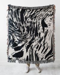 A 100% cotton throw blanket featuring a black and white marble pattern. Woven with colored threads, not printed, for a beautiful texture & depth. 37x52 inches: small size for a child or just for a lap50x60 inches: most popular size, great for throwing on a sofa60x80 inches: cover a few people on a sofa, or use as a bedspreadEasy care: machine wash with cold water; tumble dry on low.Designed by me in Canada, and woven and shipped from the USA. Colors may vary slightly due to screen differences.