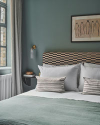 Topology Interiors updated this beautiful bedroom with a headboard upholstered in our Tuscan Lullaby linen fabric.  #interiordesign #poodleandblonde #blueinterior