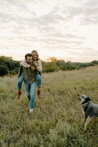 Nebraska based wedding photographer captures a dreamy outdoor engagement session in Chalco, NE showing the couple with their dog running around the field during sunset and ending the session by shotgunning beers together! #nebraskaengagementphotographer #nebraskacouplesphotographer #romanticengagementsessionideas #romanticcoupleposes