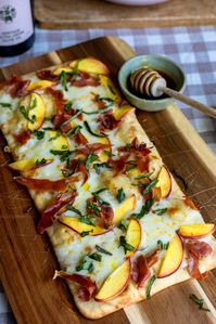 Peach prosciutto hot honey flatbread with mozzarella and basil! This combination is so ideal for any summertime event.