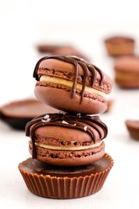 Chocolate Peanut Butter Macarons have a sweet fluffy peanut butter center enclosed by chocolaty meringue-based cookies! This delicious recipe includes step-by-step photos and tons of tips to make this classic French dessert!