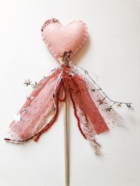 Adorable valentines heart wooden wand! Perfect for make believe and imagination! Hand stitched felt with embroidery. Adorned with lots of pretty trim and yarn. **do not leave unattended with children** Checkout my other goodies in my shop: www.daisyandjunecompany.Etsy.com