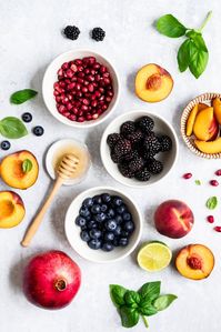 Gorgeous honey lime basil peach fruit salad made with fresh peaches, blackberries, blueberries and pomegranate. This summer peach fruit salad recipe is lightly tossed with honey, lime juice, and fresh basil leaves for a fresh side dish that's perfect for bbq's and parties! #fruitsalad #sidedish #peachrecipe #peaches #blueberries #blackberries