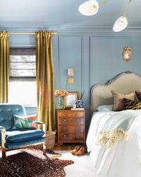 bedroom with light blue paneled walls and ceiling and traditional furniture