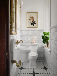 Beautiful powder room in Joanna Gaines designed castle in Waco featuring brable tiled wall and WatermarkFixtures powder room sink