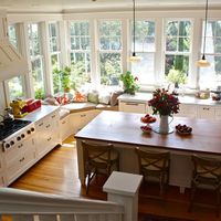 One of our favorite kitchen pics Love the extra tall windows Love that they wrap around the corner Love the unexpected window seat in corner (we really use our current bench seat in the kitchen to relax and chat) Like the cupboards and wood floors Not crazy about the wood counter on island