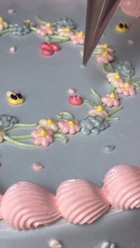 This beautiful cake has a beautiful set of leaves, vines, flowers, and bees along the sides and top. This one was made by @aprilsbakerlondon. This pin links to the TikTok it came from.