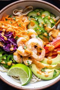 Spring Roll Bowls are filled with rice noodles and topped with crunchy, fresh veggies, shrimp, and an incredible peanut sauce!