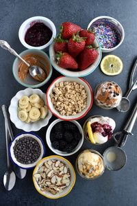 Healthier Ice Cream Sundae Bar has all of your favorite toppings including a variety of fruit, granola, nuts, sauces, chocolate chips and more. The perfect easy dessert option for a party! www.nutritionistreviews.com #icecream #icecreamsundae #sundae #dessert #partydessert #healthy