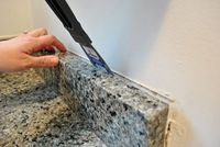 how to remove the 4" granite backsplash, because it should never, ever be installed in the first place!