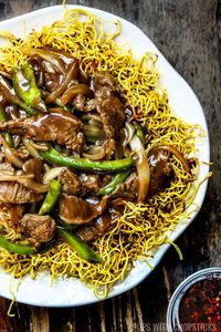 A crispy Cantonese beef chow mein recipe, loaded with a saucy beef, peppers, and onions on top. A popular and delicious takeout dish that's easy to re-create right in the comfort of your home!