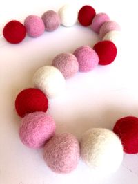 This red white and 2 shades of pink felt garland is perfect for wall, mantle and Christmas tree decor. Perfect Valentine's Day, Christmas and home decor. 3cm 100% wool felt balls made in Nepal. Measurement is with balls placed back to back. Each will come with over double the length in string so you can space balls to your liking. *Keep out of reach of small children