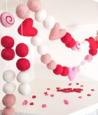 "Valentine's Day Pink, Red and White Heart Pom Pom Felt Wool Garland  -100% Wool felt pom balls(1\") + dusty pink, bright pink, red hearts (1.5\")  -Colorway: Red, Pink & White  -Felt wool shapes are strung on white twine  -The felt balls are adjustable along the string the extra twine provided is to allow for 2\" spacing, the garland is shipped condensed (push together) you can adjust to preferred spacing.   -The overall total length of the twine is not the total amount of balls if pushed toget