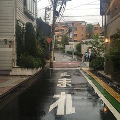 an empty street in the rain with people walking on it