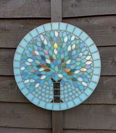 a stained glass tree on a wooden fence