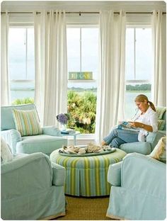 a woman sitting in a living room reading a book