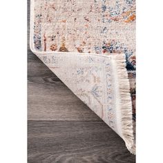 an area rug with wood flooring and wooden floors in the background, it has a beige