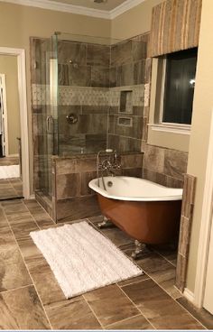 a bath tub sitting inside of a bathroom next to a walk in shower and toilet