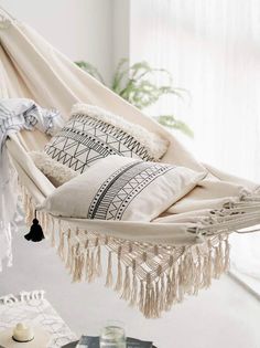 a hammock hanging in the middle of a room with pillows and blankets on it