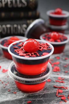 red and black bowls are stacked on top of each other with sprinkles around them