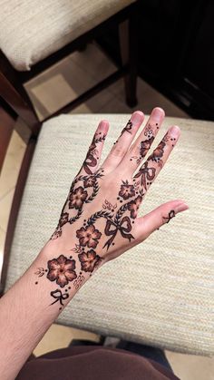 a person's hand with tattoos on it sitting in front of a chair and looking at the camera