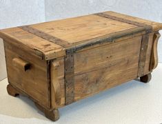 an old wooden box sitting on top of a white tableclothed flooring area