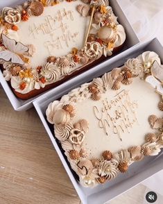 two decorated birthday cakes sitting on top of a wooden table with white frosting and gold decorations