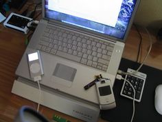 an open laptop computer sitting on top of a desk next to a mouse and cell phone