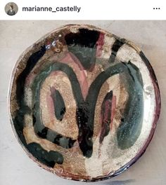 a bowl that is sitting on top of a white tablecloth with black and pink designs