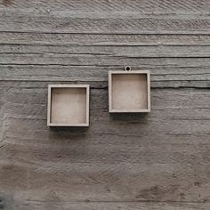 two empty boxes sitting on top of a wooden table