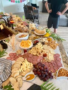 a man standing in front of a table full of different types of food and snacks