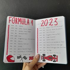 uma mão segura um caderno branco aberto na frente de uma parede preta. no topo das folhas do caderno está escrito "fórmula 1 2023", e abaixo está a lista de datas e locais da temporada 2023 de fórmula 1. na parte debaixo da folha há 4 desenhos: um capacete vermelho, duas bandeiras quadriculadas atravessadas, o número 16 vermelho e um carro de fórmula 1 vermelho. Car Journal Ideas, Formula One Journal, F1 Notebook Ideas, F1 Journal Ideas