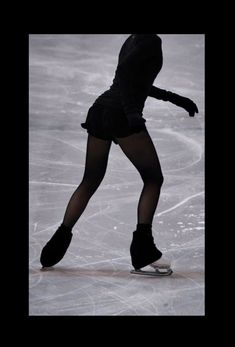 a woman skating on an ice rink wearing black