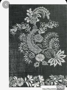 a black and white image of flowers on a linen background with an embroidered design in the middle