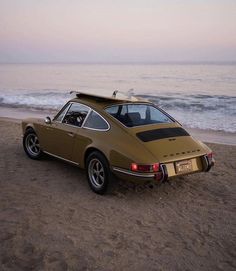 an old car is parked on the beach