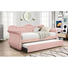 a pink daybed sitting on top of a wooden floor next to a white rug