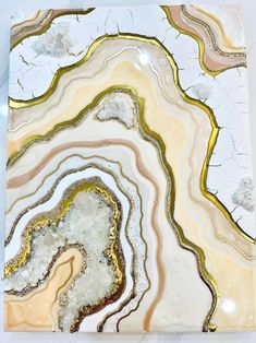 an abstract painting with gold, white and grey colors on it's surface is shown