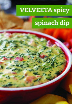 a red bowl filled with spinach dip surrounded by chips