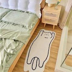 a cat rug is on the floor next to a bed