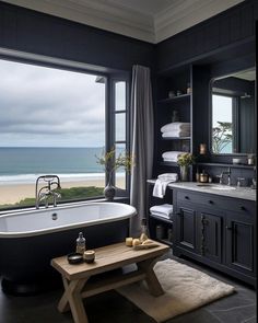 a bath room with a large window and a bath tub near a table in front of it