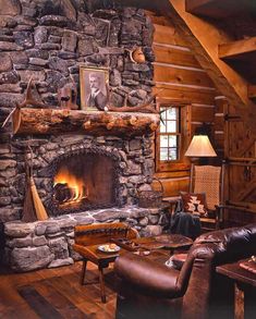 a living room with a stone fireplace and wooden floors