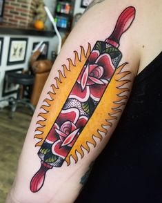 a woman with a tattoo on her arm has a knife in the middle of it